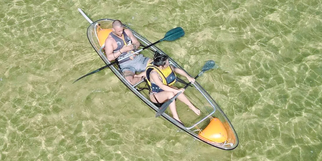Clear-hull kayak seen from directly above in shallow water